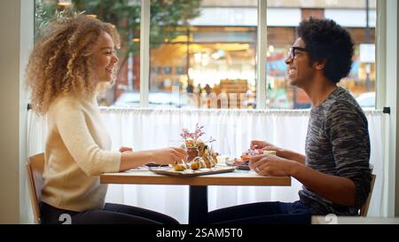 Jeune couple appréciant le repas à la date dans le restaurant de la ville ensemble Banque D'Images