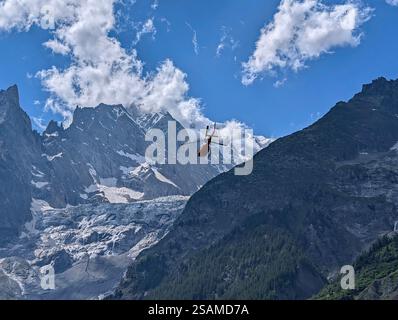 Un hélicoptère ambulance décolle pour une mission de sauvetage contre l'imposante toile de fond montagneuse des Alpes Banque D'Images