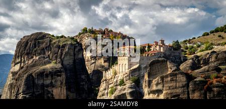 Une vue imprenable sur les formations rocheuses des Météores en Grèce, avec d'anciens monastères perchés au sommet d'imposantes falaises sous un ciel spectaculaire avec des nuages. Banque D'Images