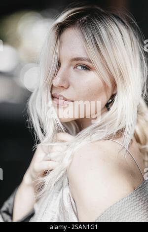 Gros plan d'une femme à l'extérieur, montrant l'expression avec la lumière du soleil et les cheveux lâches Banque D'Images