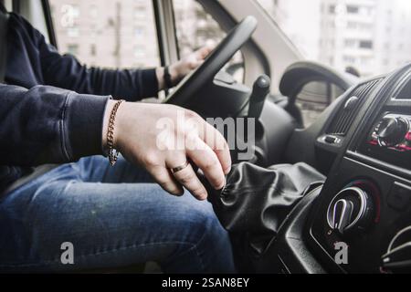 Gros plan de la main d'une personne sur un changement de vitesse manuel dans une voiture Banque D'Images