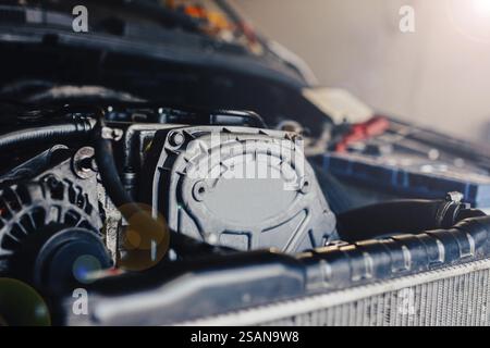 Gros plan d'un moteur de voiture avec des machines visibles et la lumière du soleil filtrant Banque D'Images