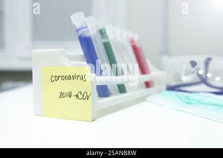 Un portoir de tubes à essai avec une note adhésive jaune étiquetée 'Coronavirus 2019-nCoV' dans un laboratoire Banque D'Images