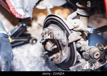 Système de freinage de voiture rouillé montré en détail dans le cadre d'un processus de maintenance Banque D'Images