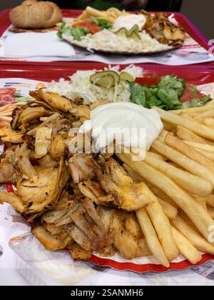 Assiette Shawarma au poulet avec pommes de terre et salade. Cuisine de rue traditionnelle au moyen-Orient. Gros plan. Banque D'Images