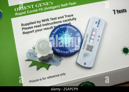 Ironie : un véritable kit de test positif COVID-19 utilisant un kit de test à flux latéral Orient Gene et un badge « J'ai été vacciné », Londres, Royaume-Uni. Banque D'Images