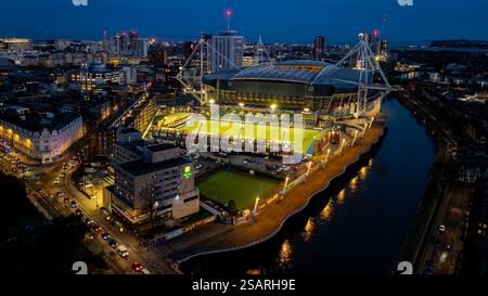 Vue aérienne du centre-ville de Cardiff la nuit, avec un stade très éclairé et la rivière Taff, mettant en valeur le paysage urbain Banque D'Images