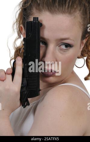 Belle Jeune femme tenant une arme de poing chargée Banque D'Images