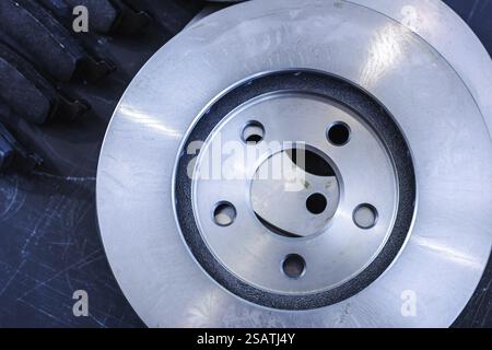 Gros plan d'un seul disque de frein métallique sur fond sombre Banque D'Images