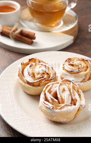 Pommes roses fraîchement cuites, miel, bâtonnets de cannelle et thé sur la table, gros plan Banque D'Images