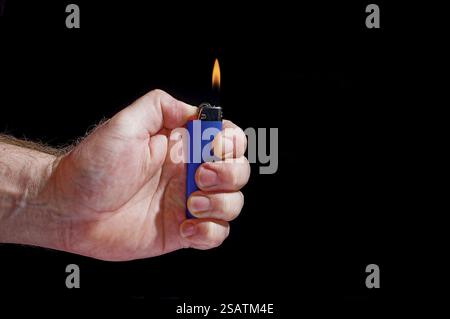 Personne allumant un briquet à butane jetable Banque D'Images