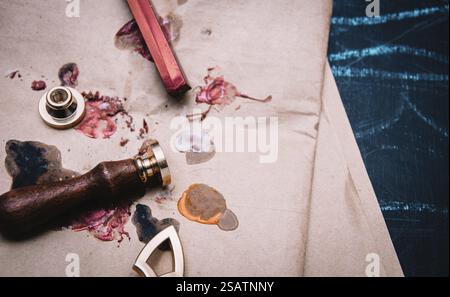 Sceller le tampon et les bâtonnets de cire rouge avec du papier teinté sur une surface bleue Banque D'Images