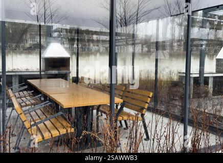 Patio extérieur tendance pergola structure d'ombre, auvent et toit de patio, table à manger, chaises, grill en métal entouré par l'aménagement paysager Banque D'Images