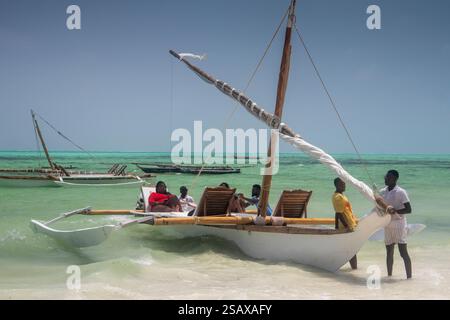 Afrique Tanzanie, Zanzibar, Côte est, Jambiani, plage, bateau d'excursion outrigger, emmenant les touristes en croisière Banque D'Images