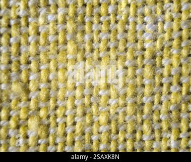 Texture détaillée d'un tissu tissé avec un motif sans couture en jaune vif et gris subtil, idéal pour diverses applications de conception. Banque D'Images