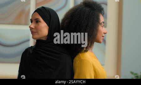 Filles multiethniques femmes deux collègues partenaires d'affaires heureuses femmes d'affaires femmes portrait au bureau diverse African American manager Muslim in Banque D'Images