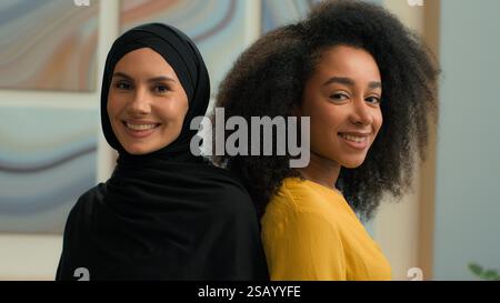 Filles multiethniques femmes deux collègues partenaires d'affaires heureuses femmes d'affaires femmes portrait au bureau diverse African American manager Muslim in Banque D'Images