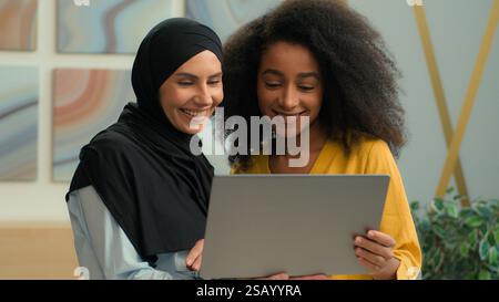 Les gens d'affaires joyeux employeur afro-américain arabe musulman musulman gestionnaire islamique dans le hijab femmes multiraciales collègues partenaires heureux souriant femme Banque D'Images
