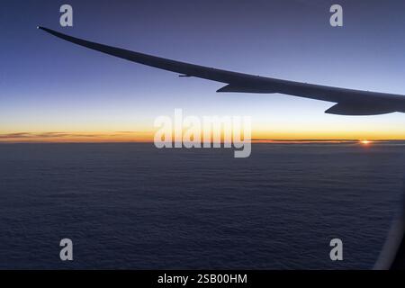 Vue sur le golfe Persique depuis la fenêtre de l'avion dans la soirée. Coucher de soleil sur les nuages. Vol avec la compagnie aérienne Etihad. Abu Dhabi, Émir arabe Uni Banque D'Images