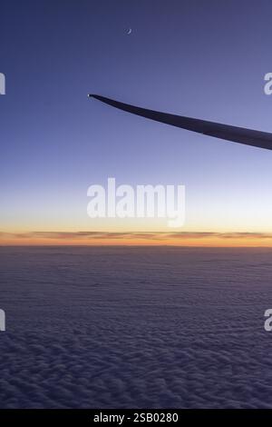 Vue sur le golfe Persique depuis la fenêtre de l'avion dans la soirée. Coucher de soleil sur les nuages. Vol avec la compagnie aérienne Etihad. Abu Dhabi, Émir arabe Uni Banque D'Images