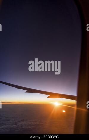 Vue sur le golfe Persique depuis la fenêtre de l'avion dans la soirée. Coucher de soleil sur les nuages. Vol avec la compagnie aérienne Etihad. Abu Dhabi, Émir arabe Uni Banque D'Images