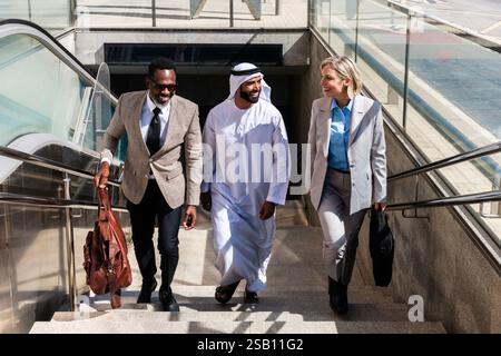 Groupe de gens d'affaires multiethniques rencontrant un homme d'affaires émirati - équipe internationale d'affaires d'entreprise liant à l'extérieur dans la ville Banque D'Images