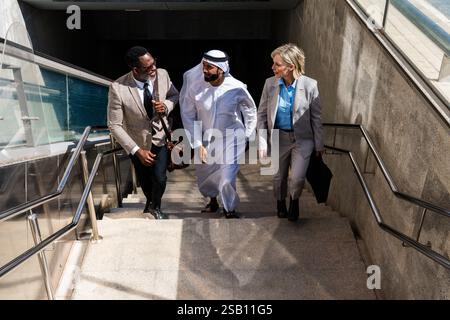 Groupe de gens d'affaires multiethniques rencontrant un homme d'affaires émirati - équipe internationale d'affaires d'entreprise liant à l'extérieur dans la ville Banque D'Images