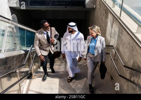 Groupe de gens d'affaires multiethniques rencontrant un homme d'affaires émirati - équipe internationale d'affaires d'entreprise liant à l'extérieur dans la ville Banque D'Images