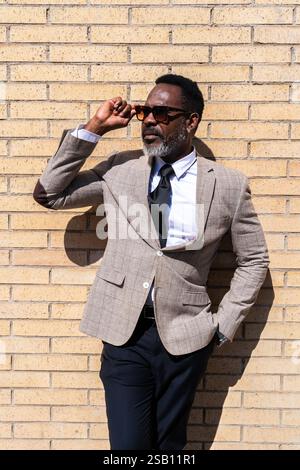 Homme d'affaires noir mature portant costume élégant se promenant dans la ville - homme senior adulte africain corporatif avec barbe grise Banque D'Images