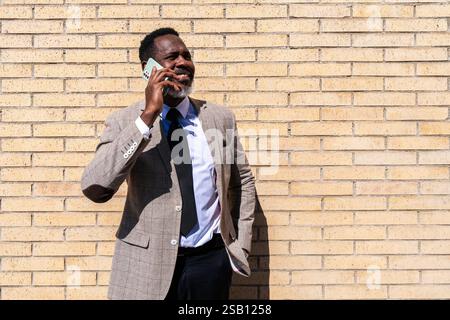 Homme d'affaires noir mature portant costume élégant se promenant dans la ville - homme senior adulte africain corporatif avec barbe grise Banque D'Images