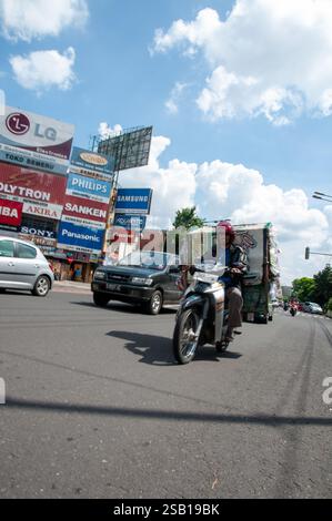 Surakarta Solo, Java central, Indonésie - 29 mai 2018 : un homme avec une moto sur la route portant une grande boîte derrière lui Banque D'Images