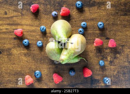 Un gros plan d'une table avec un bouquet de poires et de bleuets. Les poires sont au centre de la table et les bleuets sont dispersés autour d'elles Banque D'Images