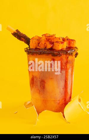 Mangonada, smoothie mexicain typique à la mangue isolé sur fond jaune. Copier l'espace. Banque D'Images