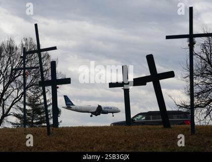 Washington, États-Unis. 31 janvier 2025. Un avion d'atterrissage est vu à travers un mémorial de croix à l'aéroport national Reagan le vendredi 31 janvier 2025 à Washington DC. Les efforts de récupération se poursuivent dans le fleuve Potomac où le vol 5342 de l'American Eagle et un hélicoptère militaire sont entrés en collision le 29 janvier, sans survivant. Photo de Ken Cedeno/UPI crédit : UPI/Alamy Live News Banque D'Images