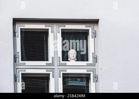 Une petite statue du Bouddha assis dans une fenêtre Banque D'Images