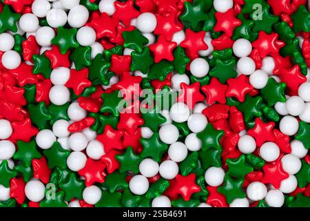 Récipient en plastique transparent rempli de perles de sucre de couleur Noël : saupoudres décoratives rouges, vertes et blanches pour la cuisson des fêtes Banque D'Images