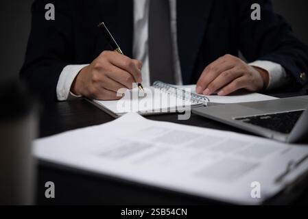 Homme tenant le stylo dans le journal d'écriture de la main, l'ordre du jour ou la recherche. Bureau d'affaires. Cahier de planificateur d'écriture sur papier Banque D'Images