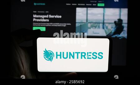 Allemagne. 06 novembre 2024. Dans cette illustration photo, une personne tient un téléphone portable avec le logo de la société américaine de cybersécurité Huntress Labs Inc sur l'écran devant la page Web de l'entreprise. (Photo timon Schneider/SOPA images/SIPA USA) *** strictement à des fins éditoriales *** crédit : SIPA USA/Alamy Live News Banque D'Images