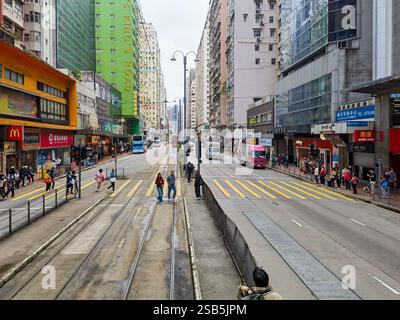 Hong Kong, Chine - 01 février 2025 : Une scène de rue de Hong Kong, mettant en vedette les tramways emblématiques au milieu de foules animées et de bâtiments imposants. L'AT Banque D'Images