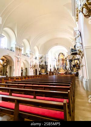 L'église est vide et les bancs sont rouges. L'intérieur est très grand et les arches sont très hautes Banque D'Images