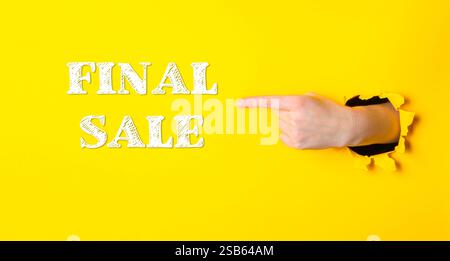 Main pointant vers le mot vente finale sur fond jaune. Concept d'urgence et d'excitation, comme si la vente était sur le point de se terminer bientôt Banque D'Images