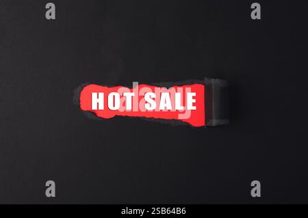 Panneau rouge avec le mot vente CHAUDE écrit dessus. Le signe est déchiré en deux, ce qui lui donne un sentiment d'urgence et d'excitation Banque D'Images