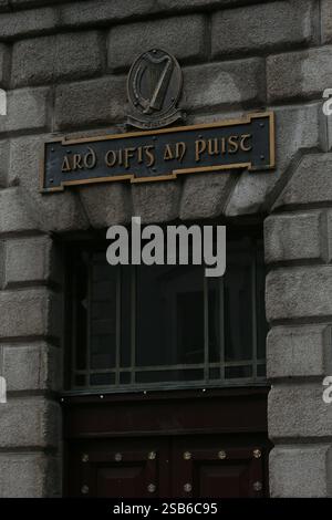 Dublin, Irlande - 28 janvier 2025 - un vieux panneau irlandais avec le titre du General Post Office (Post Office HQ) en langue irlandaise et une plaque en relief avec une grande harpe sur le mur d'entrée latéral du GPO sur O'Connell Street Banque D'Images