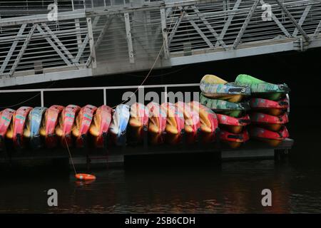 Dublin, Irlande - 28 janvier 2025 - rangées de kayaks empilés alignés à côté d'une passerelle le long de la promenade de la rivière Liffey dans la ville de Dublin Banque D'Images