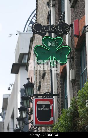 Dublin, Irlande - 28 janvier 2025 - un panneau vert en forme de trèfle allumé au néon est suspendu au-dessus d'un pub dans une rue de Temple Bar Banque D'Images