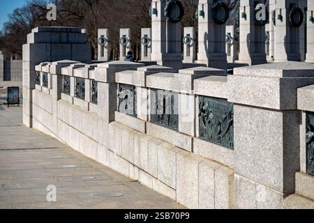 Mémorial de la Seconde Guerre mondiale sur le National Mall à Washington DC | WASHINGTON DC — Des bas-reliefs en bronze représentant des scènes du théâtre atlantique de la Seconde Guerre mondiale bordent l'entrée cérémonielle du National World War II Memorial sur le National Mall. Créés par le sculpteur Ray Kaskey, les 24 panneaux de bronze forment un récit visuel des opérations sur le champ de bataille ainsi que des contributions du front intérieur pendant le conflit mondial de 1939–1945. Les reliefs du côté nord de l'entrée sont spécifiquement dédiés aux campagnes européennes et atlantiques, et ensemble, ils constituent un témoignage durable de la guerre américaine e Banque D'Images