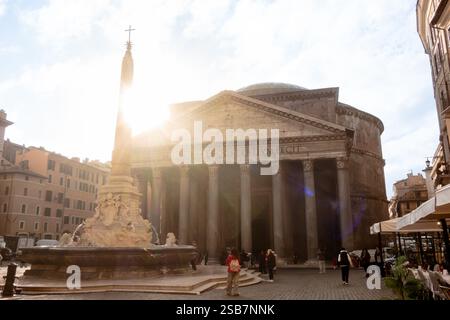 Rome, Italie - 8 janvier 2025 : touristes devant le temple historique du Panthéon et monument avec le soleil brille sur l'obélisque Banque D'Images