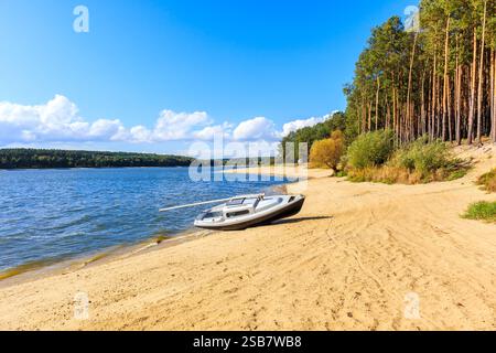Petit voilier sur une belle plage de sable au lac Chancza dans la région de Swietokrzyskie dans le centre de la Pologne Banque D'Images