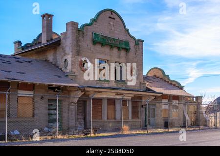 Un grand bâtiment ancien avec un toit vert et un auvent vert. Le bâtiment est vide et a beaucoup de fenêtres Banque D'Images