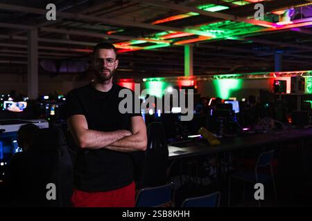Jeune homme, joueur au festival numérique, debout dans la salle informatique et regardant la caméra. Le style de vie des jeux et les concepts communautaires. Banque D'Images